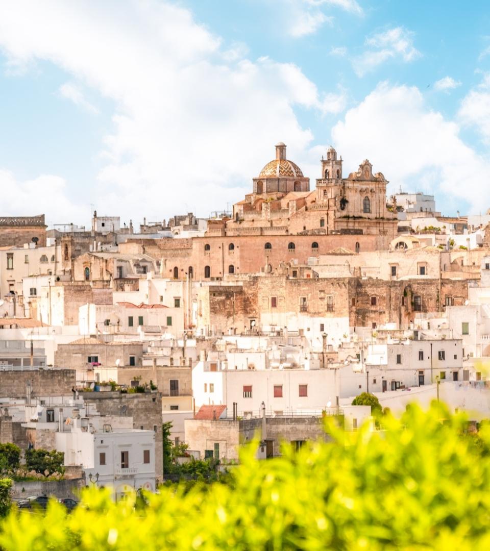 Panorama di Ostuni, la città bianca in Puglia, con edifici storici e cielo azzurro.