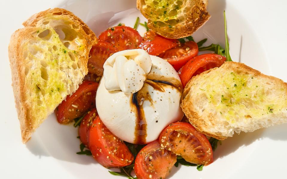 Burrata con pomodorini, rucola, crostini e aceto balsamico.